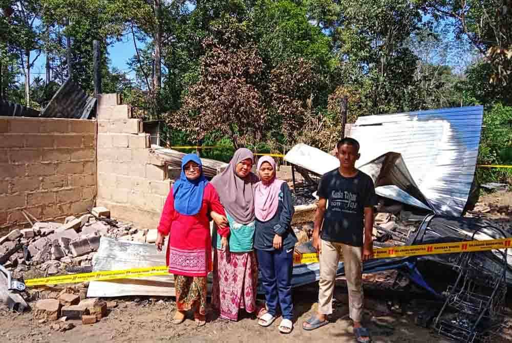 Sarina (dua dari kiri) bersama ahli keluarganya kini tinggal sehelai sepinggang selepas rumah yang didiami mereka musnah dalam kejadian kebakaran Isnin lalu.