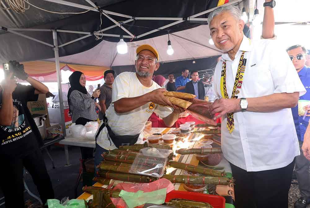 Timbalan Perdana Menteri yang juga Menteri Kemajuan Desa dan Wilayah Datuk Seri Dr Ahmad Zahid Hamidi membeli produk tempatan &#039;Lemang Sarawak&#039; semasa mengjadiri Majlis Perasmian KUD@Kota Samarahan pada Jumaat. Foto Bernama