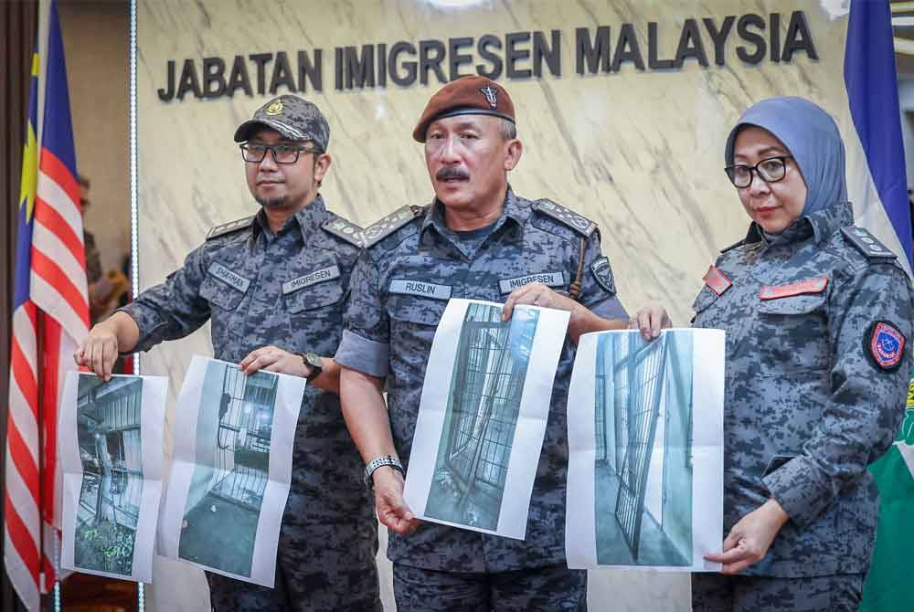 Ruslin menunjukkan gambar kesan rempuhan pada sel tahanan kepada pemberita semasa sidang media situasi terkini tahanan yang lolos dari Depot Imigresen Bidor di Ibu Pejabat JIM hari ini. Foto Bernama