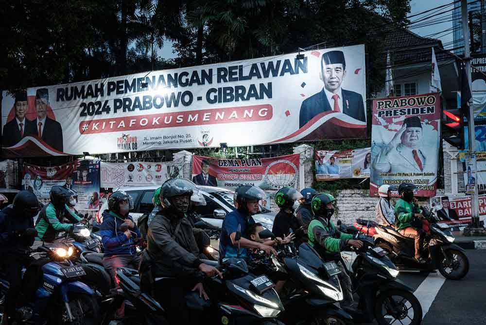 Poster calon presiden Prabowo Subianto dan Gibran Rakabuming Raka (kiri) dipasang sepanjang jalan di Jakarta menjelang pilihan raya presiden (Pilpres) 2024 pada 14 Februari depan. - AFP