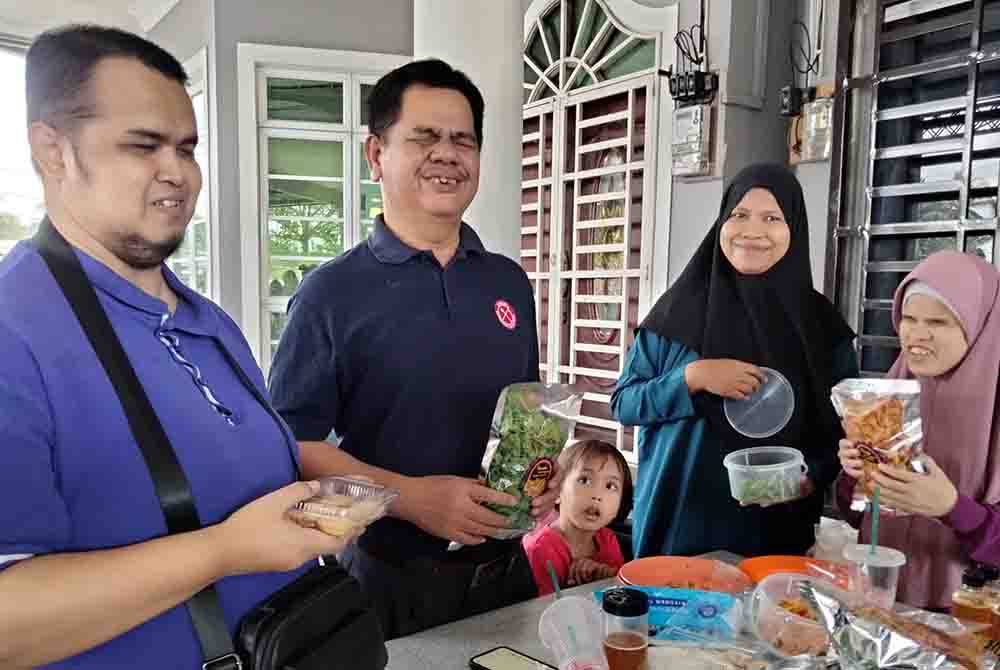 Azmi (dua dari kiri) menunjukkan kerepek yang dijual ahli Pertubuhan Orang Cacat Malaysia Cawangan Kelantan.