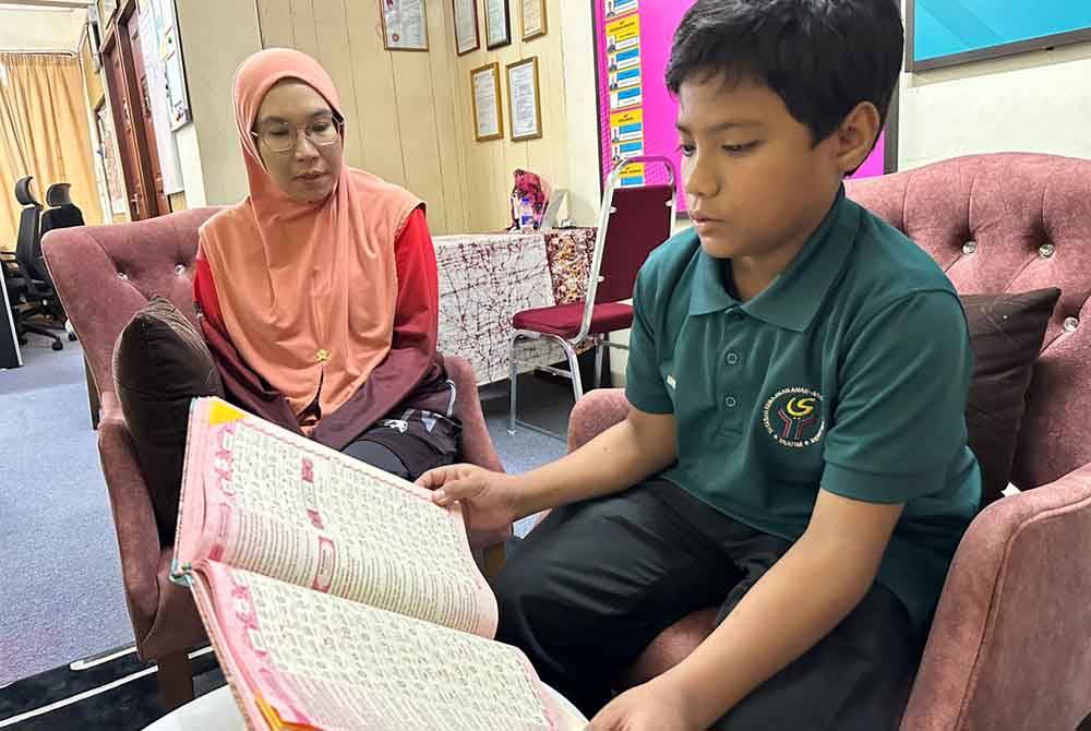 Muhammad Haifan (kanan) membaca al-Quran sambil diperhatikan oleh Nur Maslina (kiri).