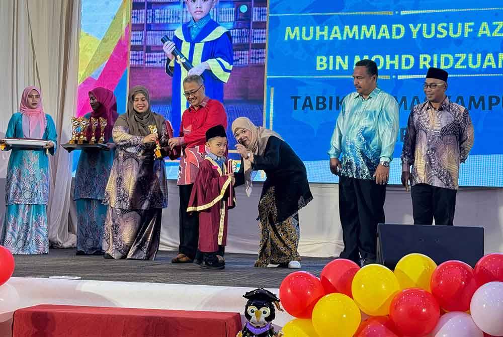 Fadhlina (tiga dari kanan) menyampaikan sijil graduasi kepada salah seorang penerima di Majlis Apresiasi Kemas Daerah Barat Daya dan Timur Laut di Dewan Sri Mutiara Raia Inn pada Ahad.