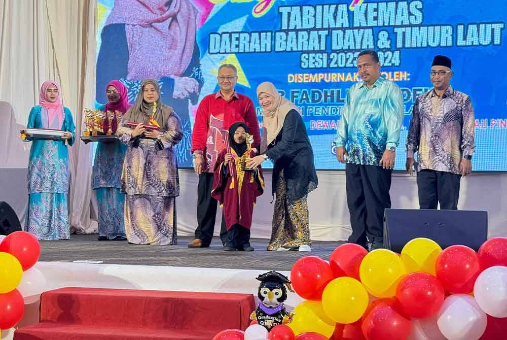 Fadhlina (tiga dari kanan) menyampaikan sijil graduasi kepada kanak-kanak di Majlis Apresiasi Jabatan Kemajuan Masyarakat (Kemas) Daerah Barat Daya dan Timur Laut di Dewan Sri Mutiara Raia Inn pada Ahad.