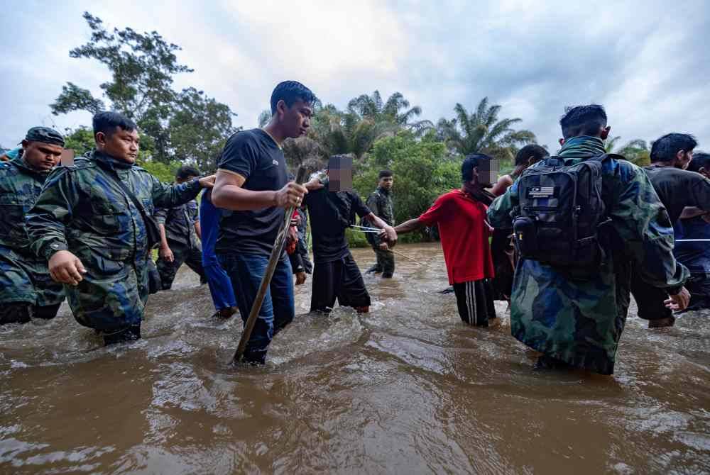 13 PATI yang meloloskan diri dari Depot Imigresen Sementara Bidor telah ditahan di sebuah kebun jambu di Kampung Senta. Foto Bernama