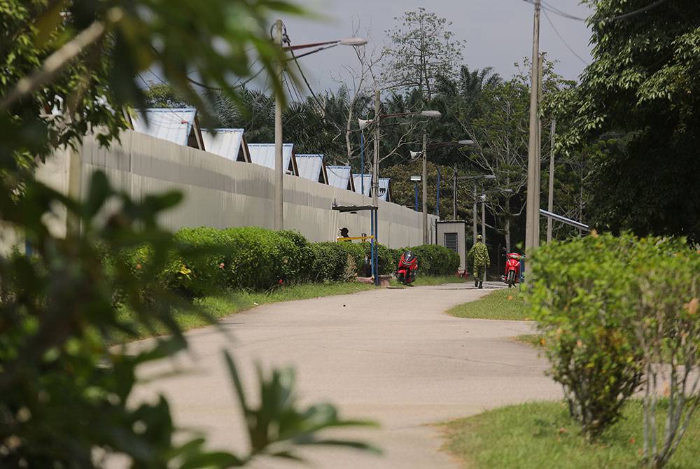 Anggota Rela memasang pita keselamatan di sekitar depot Tahanan Imigresen Sementara Bidor. Foto Bernama