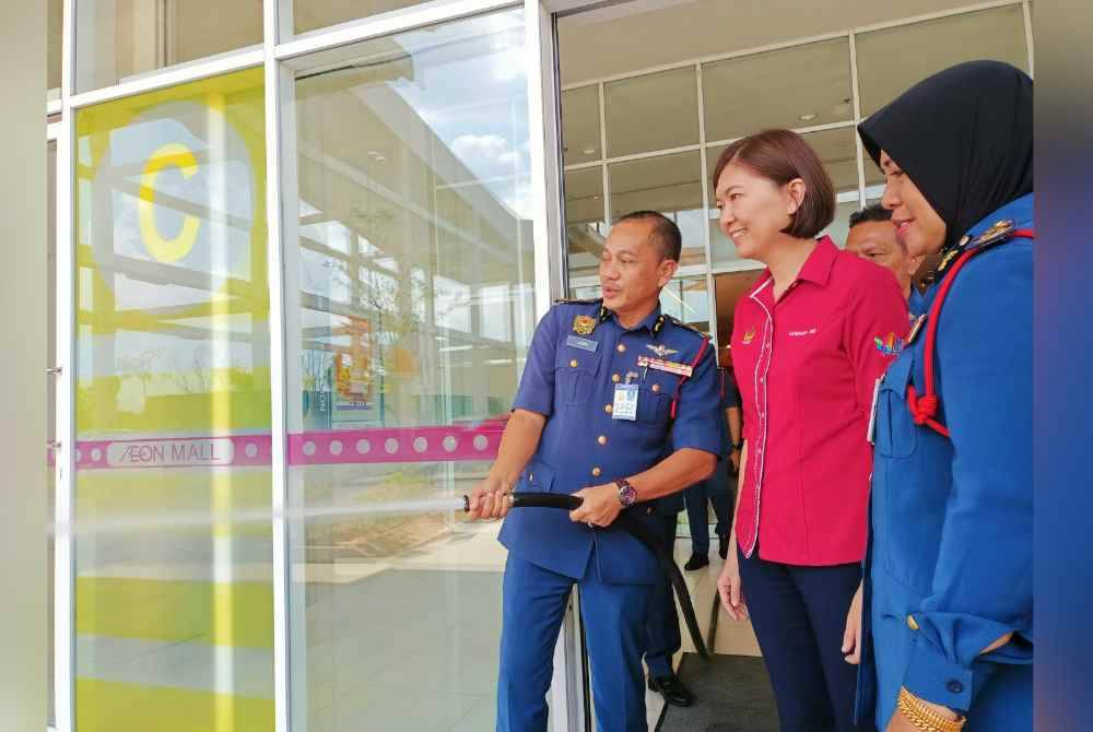 Sayani (kanan) dan Sandrea ketika melihat pemeriksaan pili bomba dalam Kempen Menghapus Bahaya Kebakaran dan Kempen Keselamatan Kebakaran sempena Tahun Baharu Cina 2024 di Pasar raya AEON Klebang dekat Chemor pada Isnin.