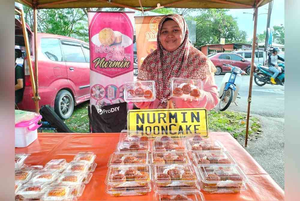 Nur Solihah menunjukkan antara kuih bulan yang dijual ketika ditemui di Pasar Tani Padang Hiliran, Kuala Terengganu.