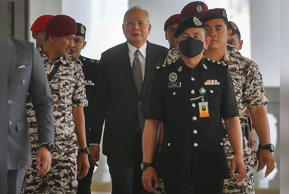 Najib (tengah) masih berdepan empat pertuduhan menggunakan kedudukan untuk memperoleh suapan berjumlah RM2.3 bilion daripada dana 1Malaysia Development Berhad (1MDB) dan 21 pertuduhan pengubahan wang haram.