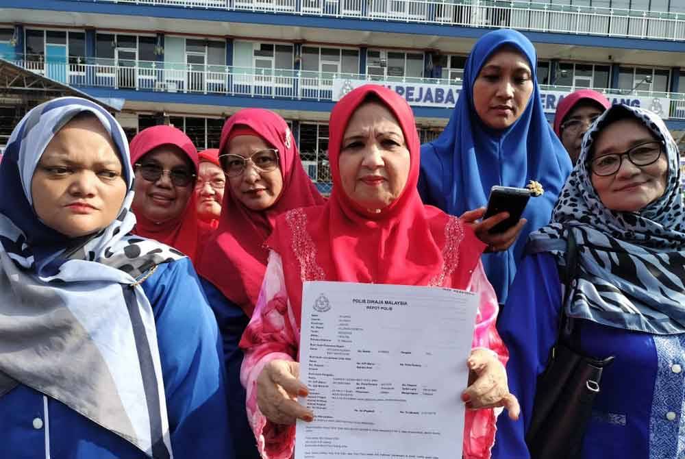 Sharifah Azizah menunjukkan salinan laporan yang dibuat terhadap Tony Pua di pekarangan IPD Kluang, Kluang, pada Selasa