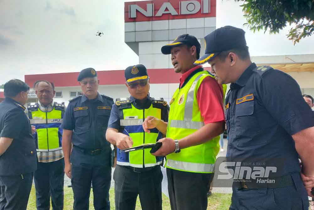 Lokman (tiga dari kanan) mendengar penerangan daripada petugas JPJ yang melakukan pemeriksaan bas di Depoh Transnasional, Sungai Chua, Kajang, Selangor sempena Ops JPJ Depoh Khas Bulan Perayaan.