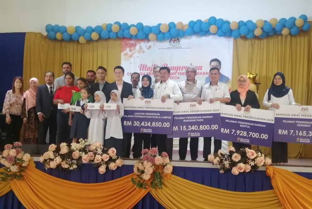 Kah Woh (lapan dari kanan) pada Penyerahan Cek Cura Bantuan Awal Persekolahan Tahun 2024 peringkat WPKL di Sekolah Kebangsaan St Mary di Taman Intan Baiduri pada Rabu.