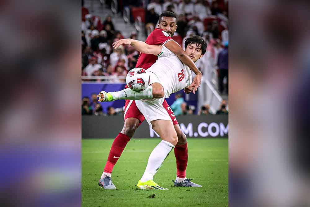 Pemain Iran, Sardar Azmoun diasak pemain Qatar, Almahdi Ali Mukhtar pada perlawanan separuh akhir Piala Asia 2023 antara Iran dan Qatar di Stadium Al Thumama pada awal pagi Khamis. Foto Bernama