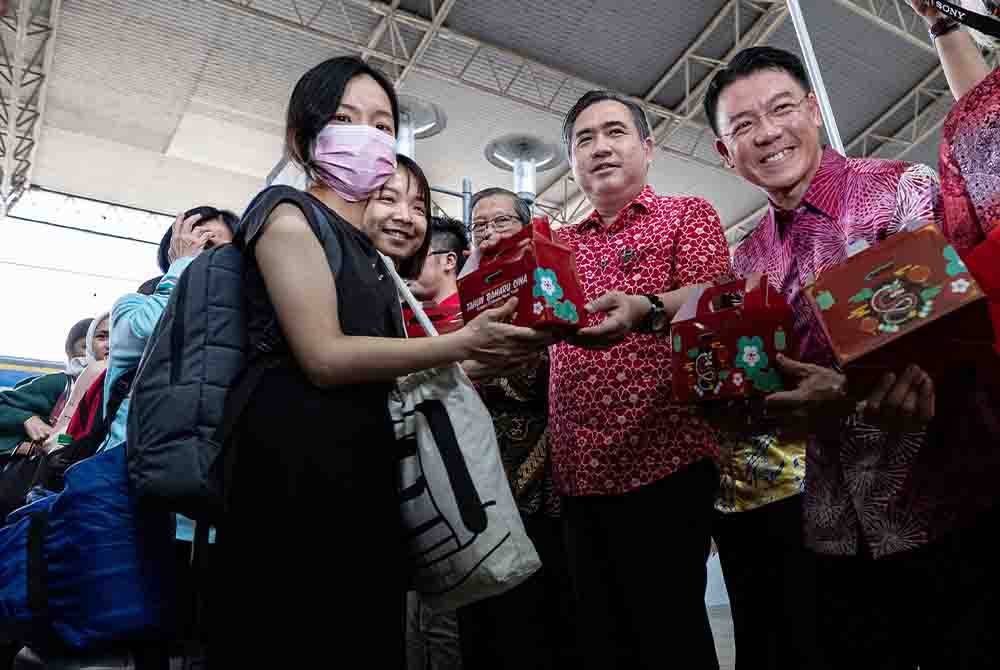 Anthony (tiga dari kanan) menyantuni para penumpang yang tiba dari Kuala Lumpur selepas melancarkan Sistem Pembayaran Terbuka KTMB dan Edaran Pek Cenderahati sempena cuti perayaan Tahun Baharu Cina di Stesen Keretapi Ipoh pada Khamis. Foto Bernama