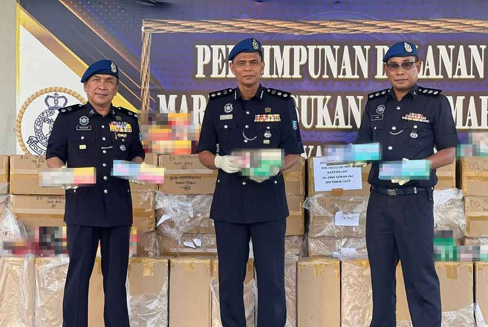 Rusley (tengah) bersama pegawainya menunjukkan rokok seludup yang dirampas.