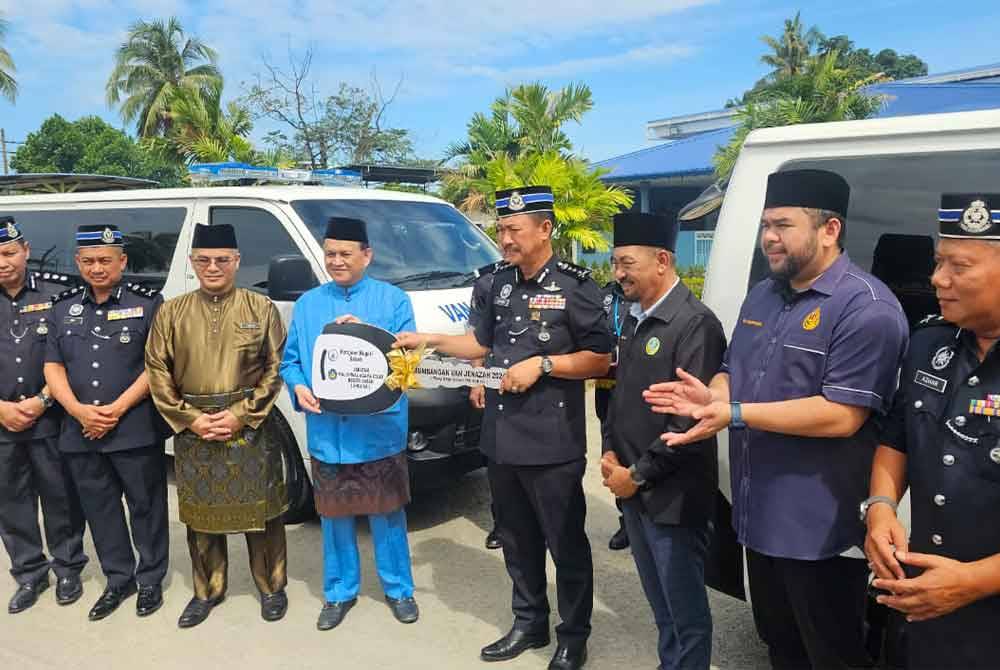 Jauteh (empat dari kanan) menerima replika kunci van jenazah yang disampaikan Mohd Arifin (empat dari kiri) di pekarangan Masjid Nur Islam IPK Sabah, Kota Kinabalu.