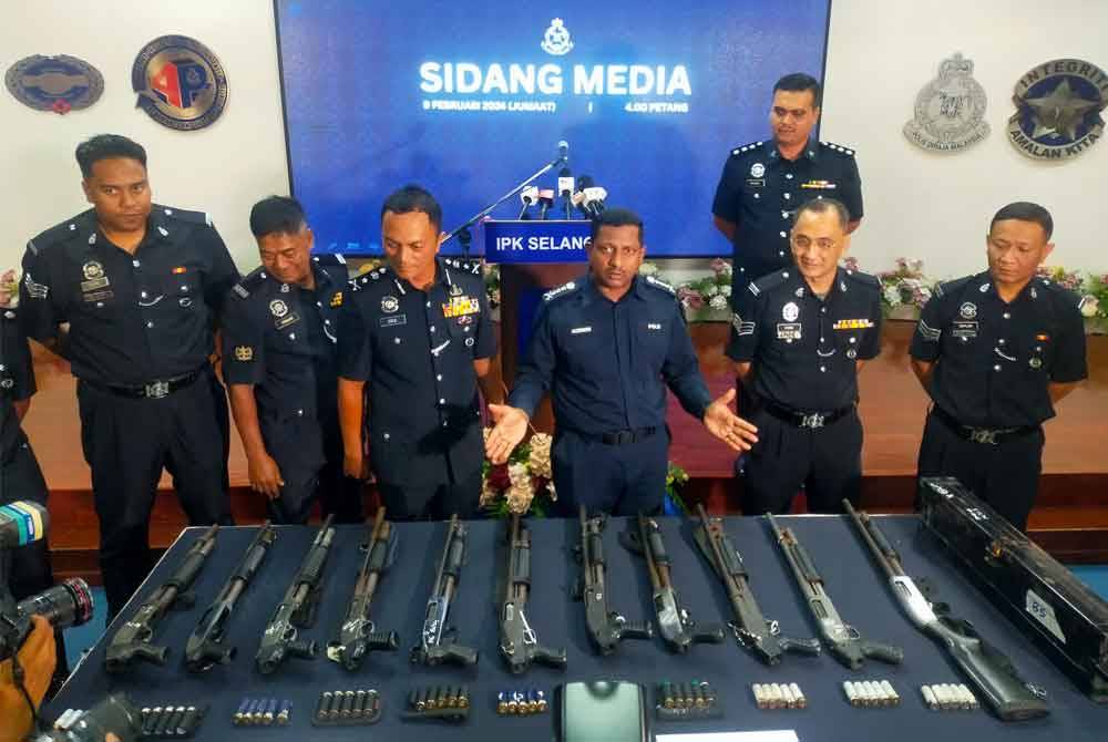 Hussein (tiga dari kanan) menunjukkan senjata api jenis pump gun dan peluru yang dirampas dalam dua serbuan dilakukan di rumah petugas pengawal keselamatan di Kuala Selangor dan Sabak Bernam, Selangor baru-baru ini. Foto HISYAMUDDIN AYU