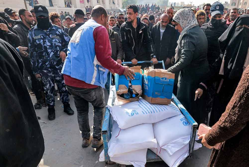 Kakitangan UNRWA mengedarkan tepung dan bantuan makanan kepada penduduk di Genting Gaza. - AFP