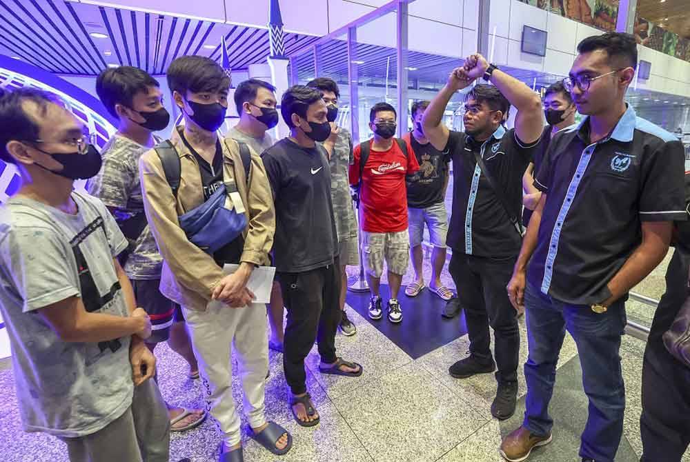 Hishamuddin (dua dari kanan) dan Azirul Syafiq (kanan) bertemu dengan sepuluh mangsa sindiket wang pelaburan kripto di Myawaddy, Myanmar sejurus tiba di KLIA Terminal 1 pada Jumaat selepas di selamatkan oleh MHO. - Foto: Bernama