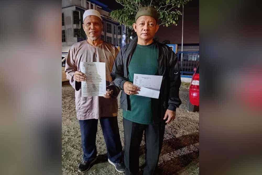 Zamrin (kanan) menunjukkan salinan laporan polis dibuat terhadap warga Singapura yang didakwa menghina Yang di-Pertuan Agong dan Perlembagaan Malaysia di IPD Seri Alam, Johor Bahru pada malam Sabtu.