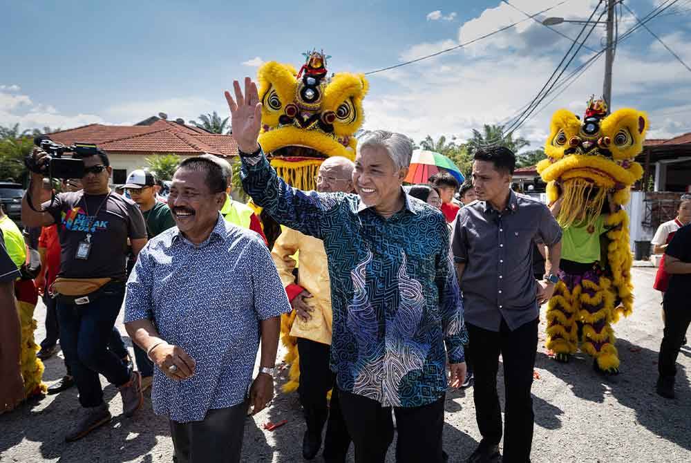 Ahmad Zahid melambai kepada tetamu ketika hadir pada Majlis Kunjungan Kasih Tahun Baharu Cina di Taman Desa Bersatu Simpang Empat, Hutan Melintang, hari ini. Foto Bernama