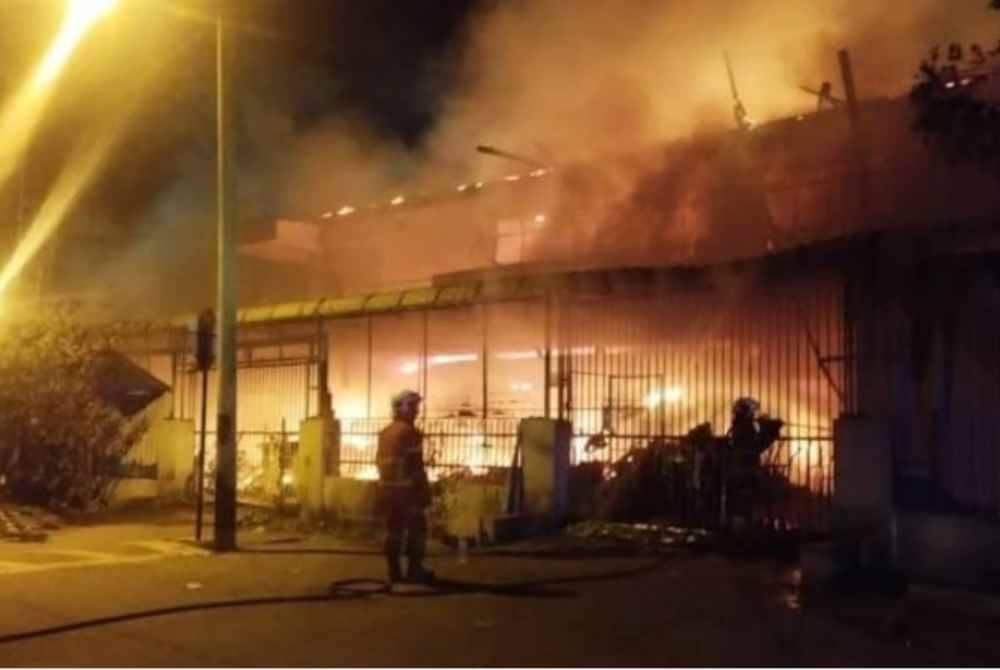 Anggota bomba memadam api yang marak dalam kebakaran sebuah rumah kedai dua tingkat di Kampung Baru Ayer Tawar, Manjung, malam tadi.