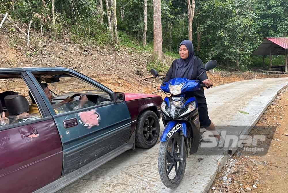 Orang ramai yang melalui jalan konkrit yang siap 60 peratus.