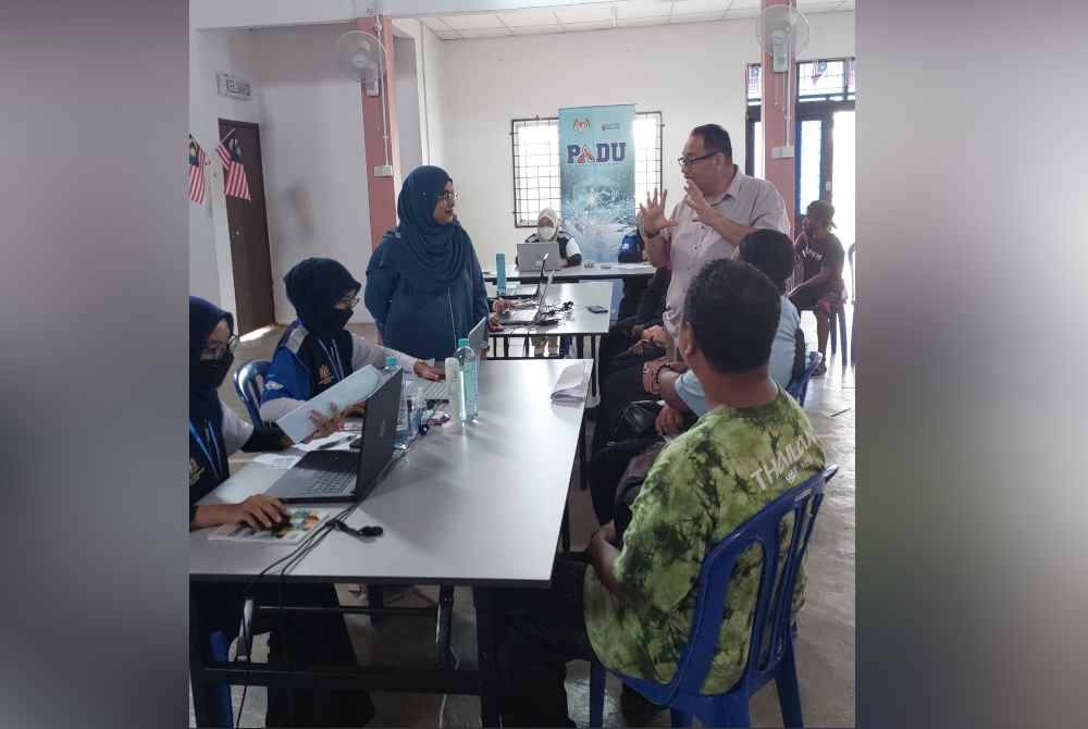 Marlini (kiri) ketika membuat tinjauan di Dewan Orang Ramai Kampung Orang Asli Sungai Pergam, pada Selasa.