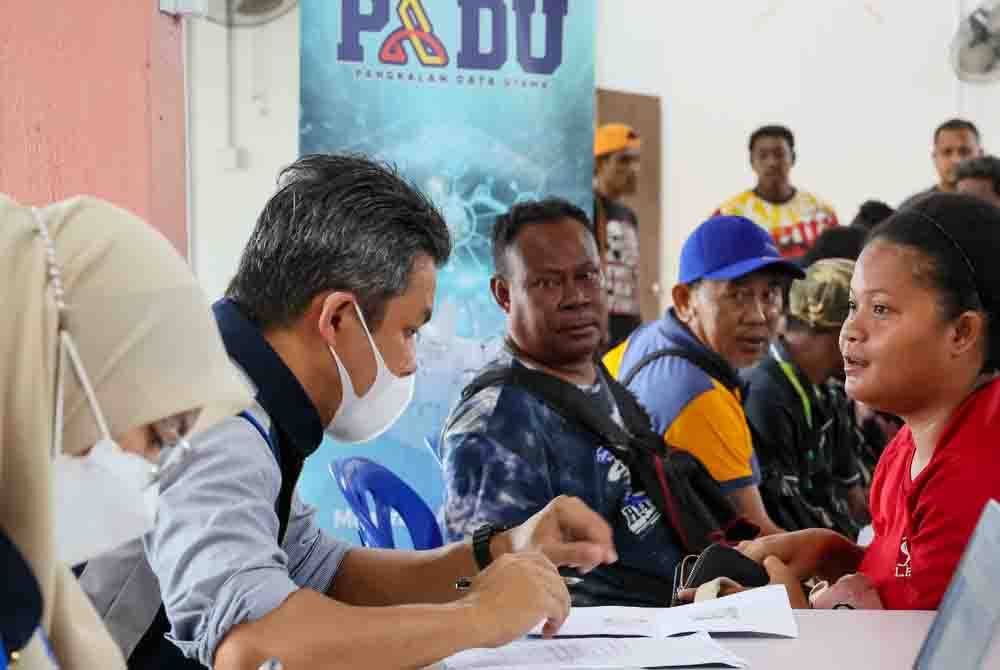 Pegawai Jabatan Perangkaan Malaysia Negeri Terengganu membantu penduduk Orang Asli mendaftar akaun dalam PADU di Kampung Orang Asli Sungai Pergam, Kemaman, pada Selasa. Foto Bernama