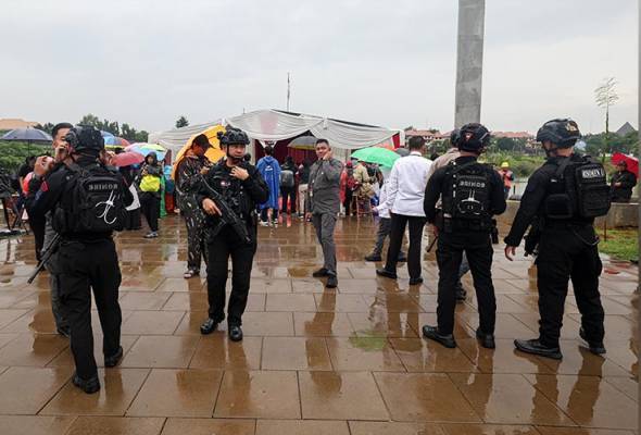 Anggota pasukan berkuasa tempatan mengawal keadaan di sekitar Tempat Pemungutan Suara (TPS) 060 Lebak Bulus, Jakarta Selatan pada Pilihan Raya Presiden Indonesia hari ini. Foto Bernama