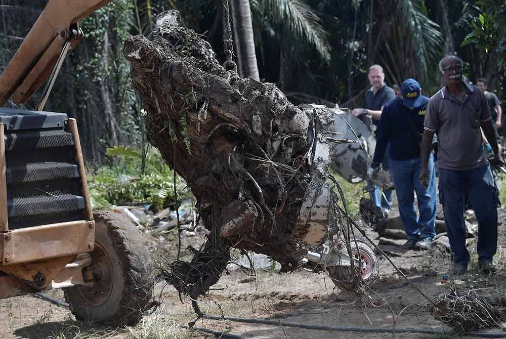 Anggota Biro Siasatan Kemalangan Udara mengangkat keluar enjin pesawat ringan model BK 160 Gabriel yang terhempas di Kampung Tok Muda di Kapar semalam, dan dibawa ke sebuah hangar di Subang untuk siasatan ketika tinjauan di lokasi kejadian pada Rabu. - Foto Bernama