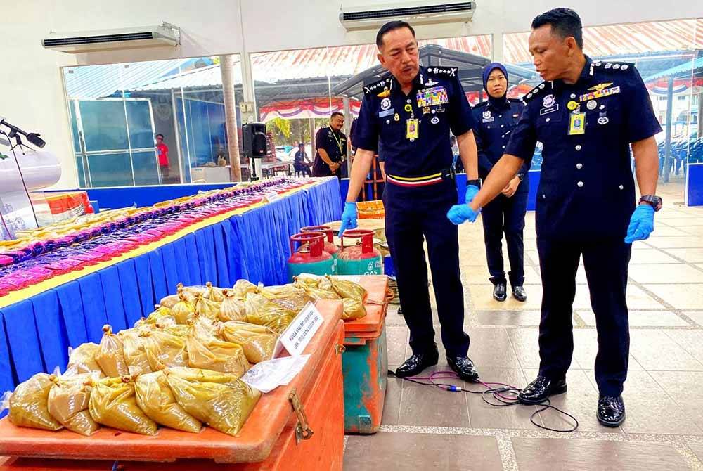 Muhamad Zaki (dua,kanan) menunjukkan air ketum yang dirampas semasa sidang akhbar di IPK Kelantan pada Rabu.