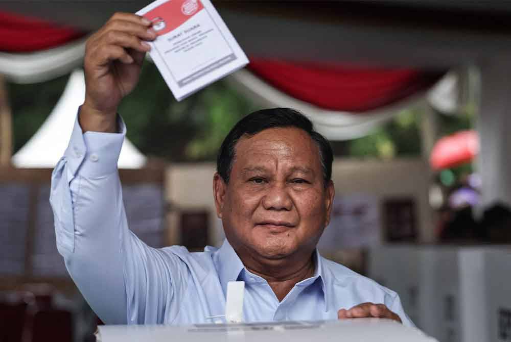 Prabowo mengangkat kertas undinya ketika beliau menunaikan tanggungjawab mengundi di Bogor pada Rabu. - AFP