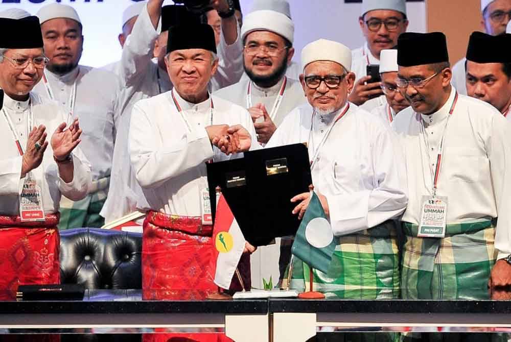 Presiden UMNO, Datuk Seri Dr Ahmad Zahid Hamidi dan Presiden Pas, Datuk Seri Abdul Hadi Awang bertukar-tukar dokumen selepas menandatangani Piagam MN sempena Himpunan Penyatuan Ummah di Pusat Dagangan Dunia Putra pada 14 September 2019.