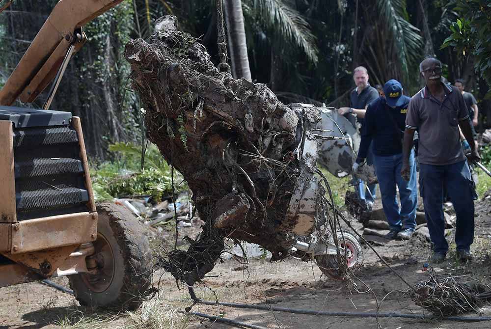 Anggota Biro Siasatan Kemalangan Udara mengangkat keluar enjin pesawat ringan model BK 160 Gabriel yang terhempas di Kampung Tok Muda di Kapar. Foto Bernama