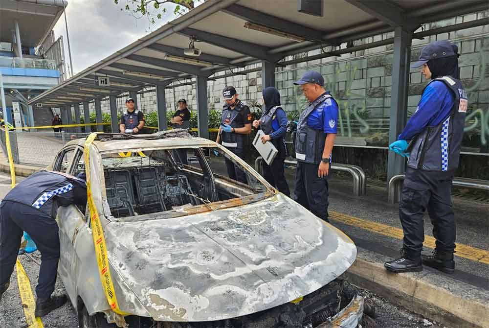 Anggota polis berada di lokasi kejadian bagi menyiasat kes bakar kereta polis bantuan di MRT Mutiara Damansara, Petaling Jaya, Selangor pada Khamis. - Foto: PDRM