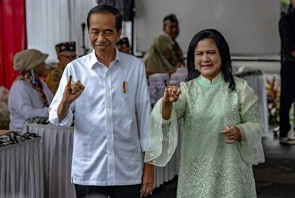 Jokowi dan isterinya, Iriana Joko Widodo menunjukkan jari dakwat mereka selepas membuang undi semasa pemilihan presiden dan legislatif di sebuah pusat mengundi di Badan Pentadbiran Negara di Jakarta pada 14 Februari lepas. Foto AFP