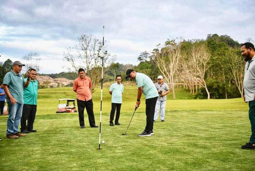 Fadzli (tengah) mencuba beraksi di lapangan padang golf Raub ketika sesi meninjau di lapangan itu pada Khamis. Foto FB Fadzli Kamal