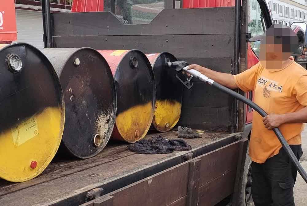 Salah seorang pemandu lori yang ditahan kerana mengisi minyak diesel bersubsidi ke dalam tong drum atas lorinya tanpa permit