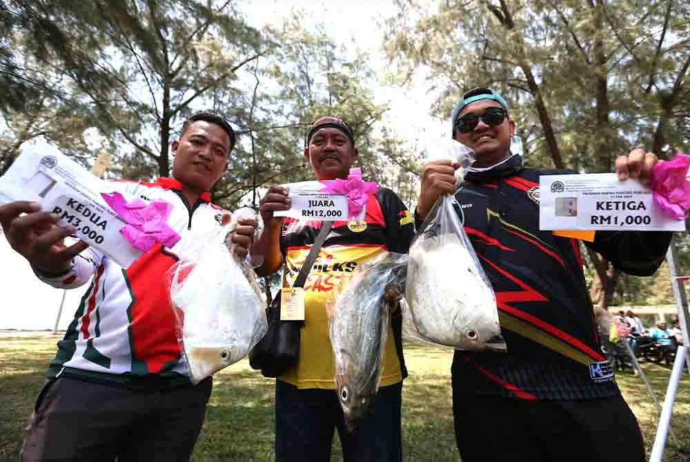 Zulkefli (tengah), Mohd Rashidi (kiri) dan Mohammad Afiq Afifi bersama ikan serta hadiah masing-masing dalam Pertandingan Santai Pancing anjuran Majlis Perbandaran Port Dickson pada Sabtu.