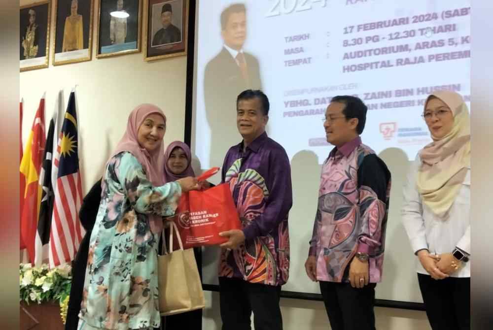 Dr Imi Sairi (dua dari kanan) mengiringi Pengarah Kesihatan negeri Kelantan, Datuk Dr Zaini Hussin (tengah) menyampaikan sumbangan kepada pesakit kanser.