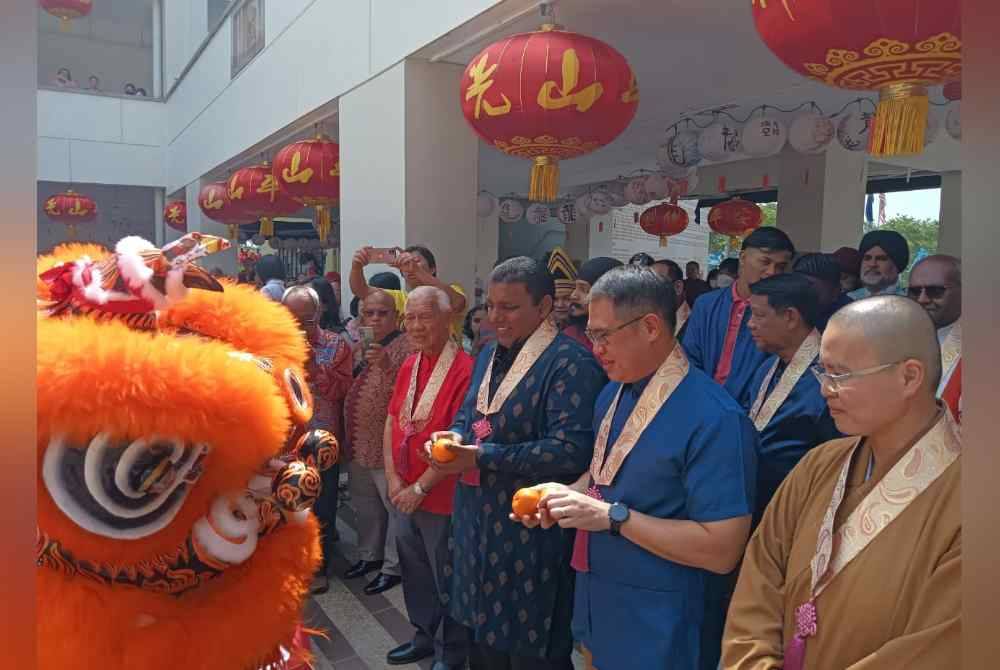 Tian Soon dan Raven (tengah) melihat persembahan tarian singa dalam Program Harmoni Bersama Sempena Tahun Baru Cina Tahun 2024 di Tokong Fo Guang Shan, Taman Sutera Utama, Johor Bahru pada Sabtu