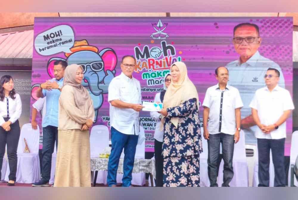 Wan Rosdy (tengah) menyampaikan sumbangan cek kerajaan negeri kepada penerima sempena Moh Karnival Makmur 2024 peringkat Daerah Maran.