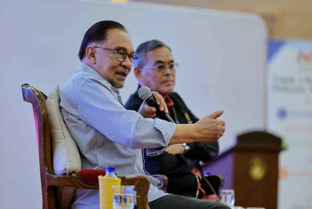 Anwar (kiri) ketika sesi soal jawab pada perasmian penutup Pemukiman Setiausaha Akhbar dan Ketua Komunikasi Korporat, di Kementerian Komunikasi, hari ini. Foto Bernama