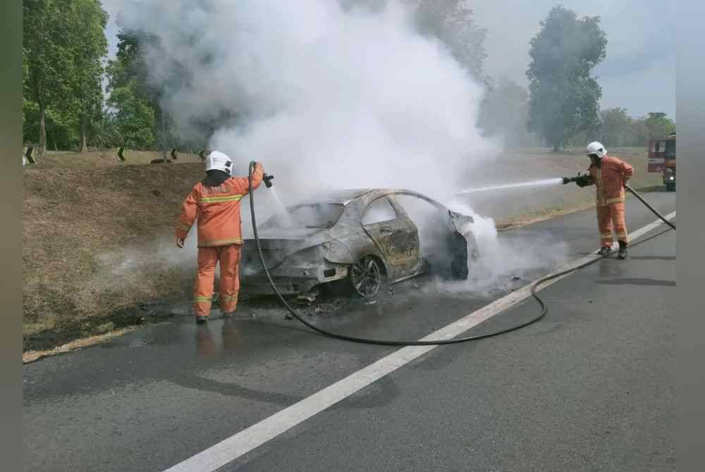 Anggota bomba dan penyelamat memadamkan kebakaran melibatkan sebuah kereta jenis Mercedes di Lebuhraya Utara Selatan pada Ahad.