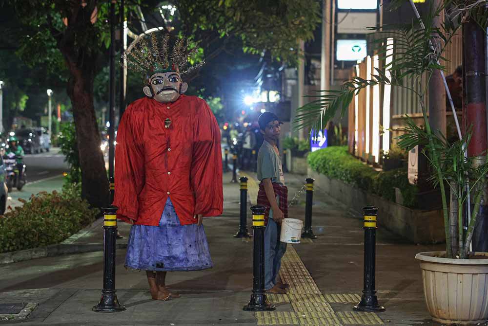 Sebuah kostum gergasi yang dikenali sebagai Ondel-Ondel, dipakai oleh seorang penghibur jalanan ketika tinjauan di sekitar ibu kota Jakarta baru-baru ini. - Foto Bernama