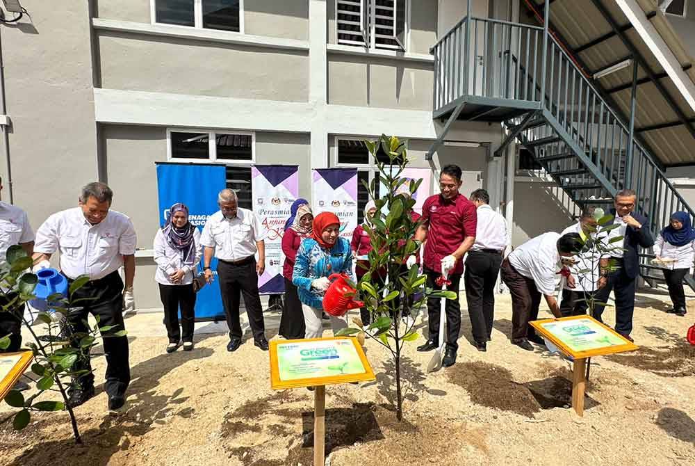 Nancy (tengah) menanam pokok sebagai simbolik perasmian Anjung Kasih Yayasan YKN di HRPZ II.