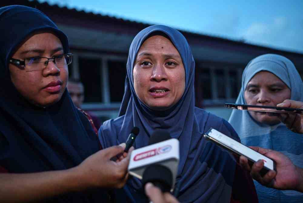 Nora Elina (tengah) ketika bertemu pengamal media semasa tiba di perkarangan Jabatan Perubatan Forensik Hospital Kuala Terengganu untuk proses pengecaman mayat suaminya, Zulkarnain Mohamed Zubir, 44, selepas kejadian lemas di Pantai Batu Buruk semalam. - Bernama