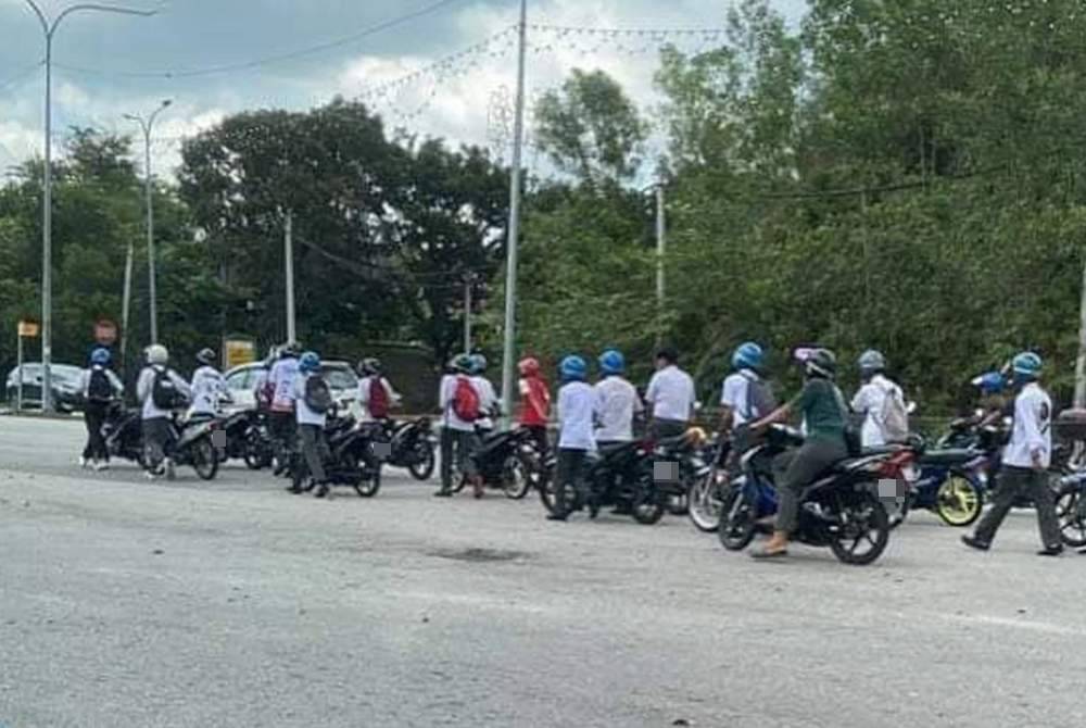 Sebahagian pelajar Tingkatan Lima sebuah sekolah menengah menolak motosikal masing-masing selepas ditahan polis kerana membuat bising.