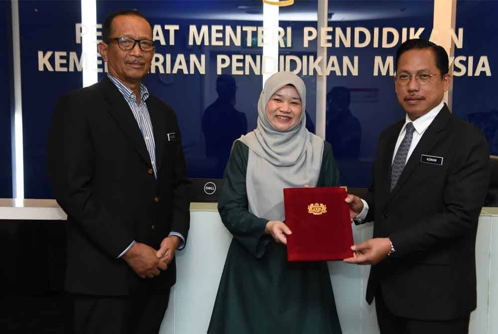 Menteri Pendidikan, Fadhlina Sidek menyerahkan watikah pelantikan kepada Azman (kanan) dan disaksikan oleh Ketua Setiausaha KPM, Datuk Nik Nasarudin Mohd Zawawi.